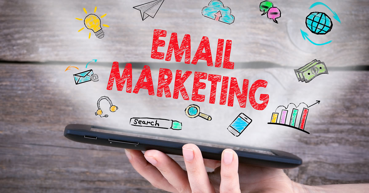 The words email marketing above a hand holding an electronic tablet
