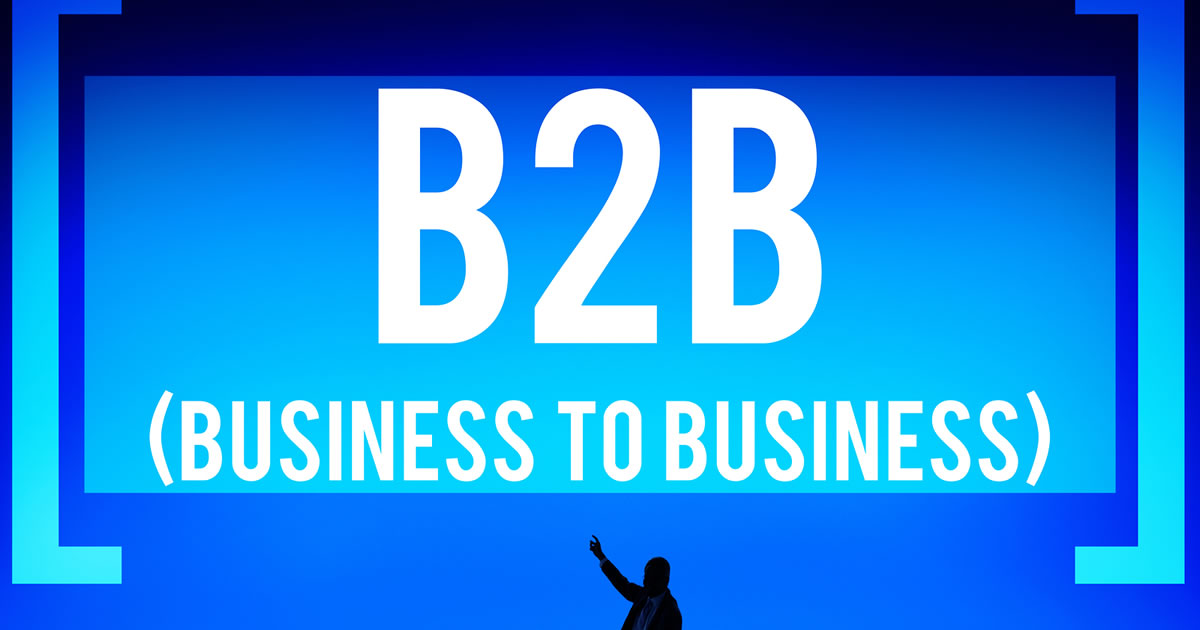 Silhouette of businessman pointing up at words B2B Business to Business