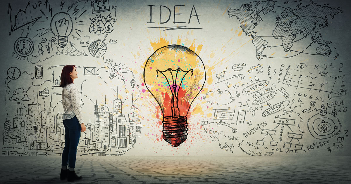 Side view of a young woman looking at a wall covered with a business sketch and a colorful light bulb and the writing IDEA in big letters