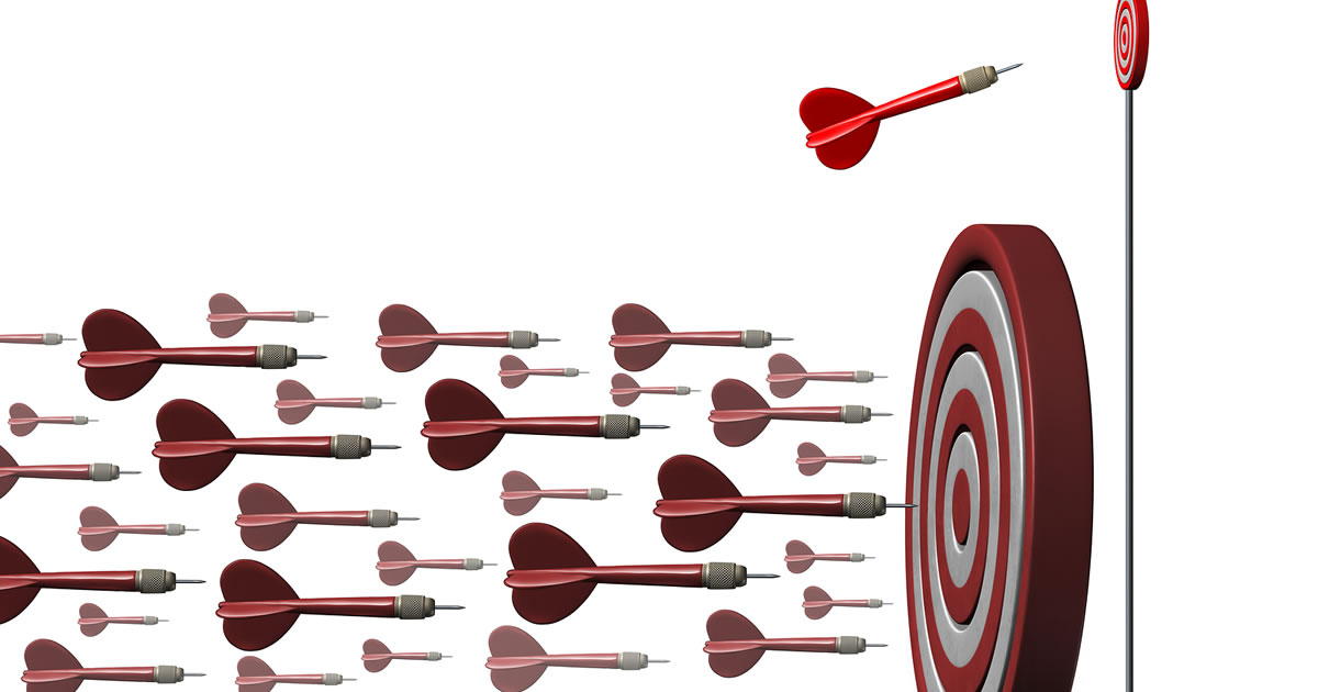 Niche specialization concept illustrated by an individual dart going toward a focused target opportunity away from a large group of darts as a metaphor for strategic specialization