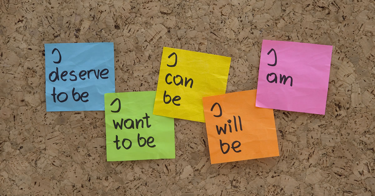 Colorful sticky notes with I deserve to be, I want to be, I can be, I will be, I am, all on bulletin board