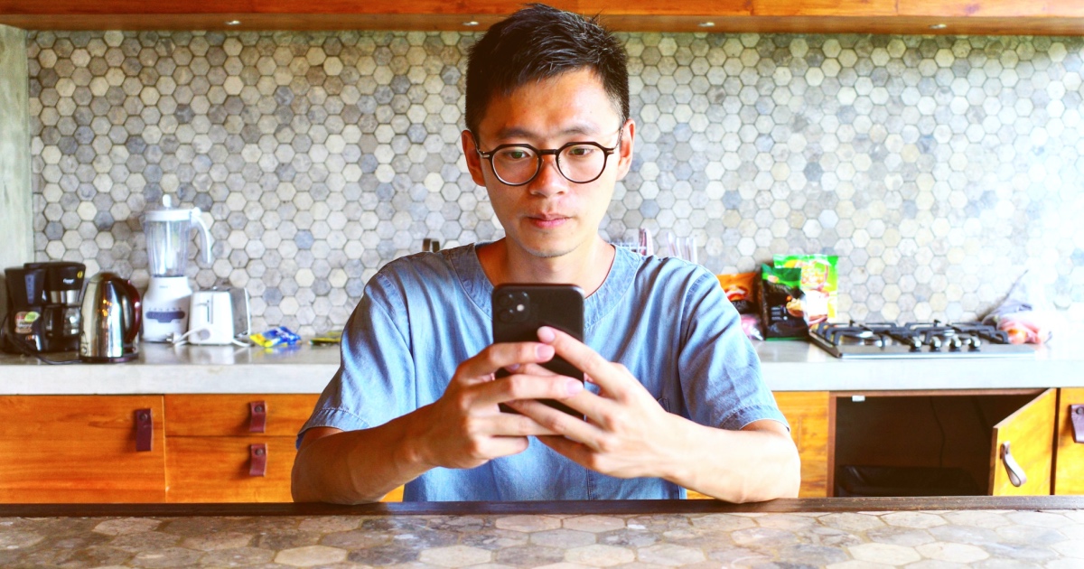 A man using smartphone in a modern decorated kitchen