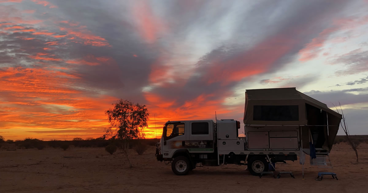 Andrew and Peta’s “travelling home” in the Australian desert at sunrise