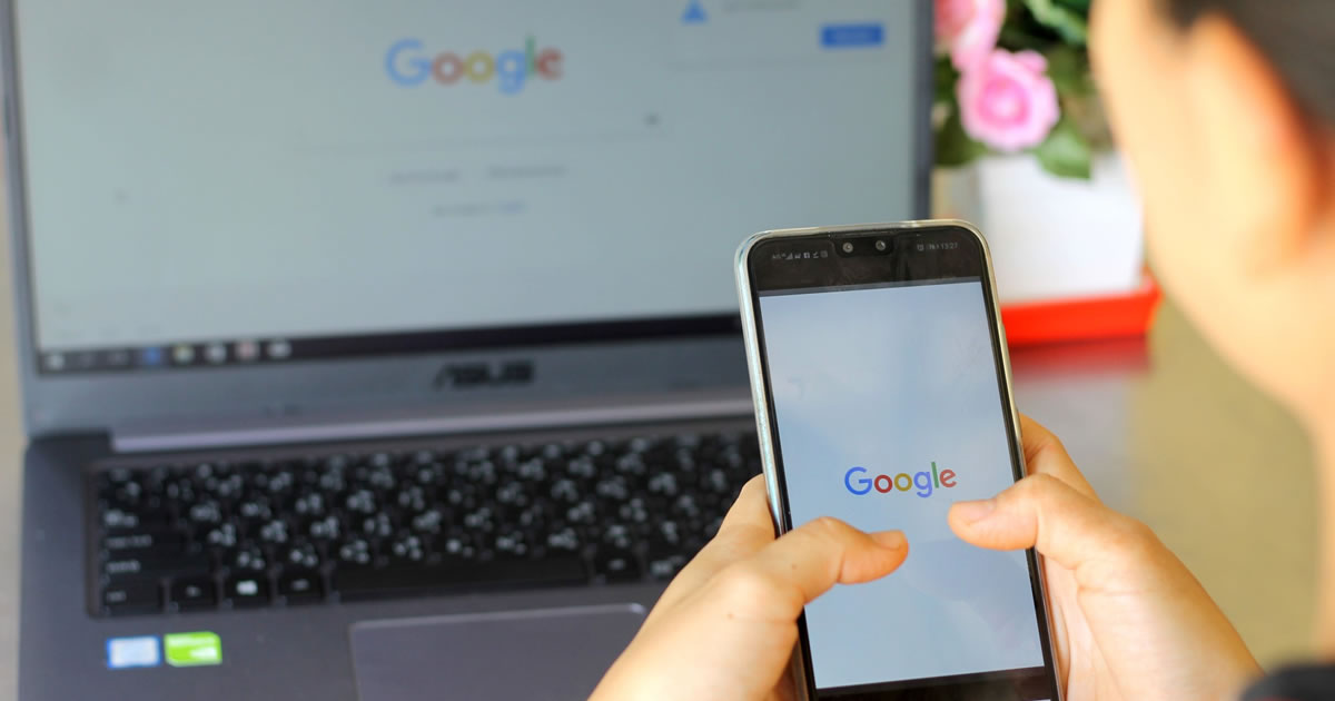 Woman searching Google on smartphone and laptop