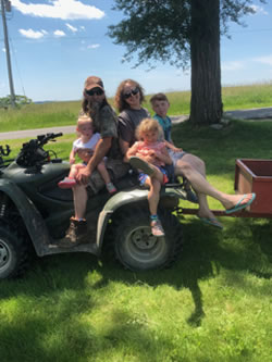 Photo of writer Janet Davis on the farm with her husband and three of their grandchildren