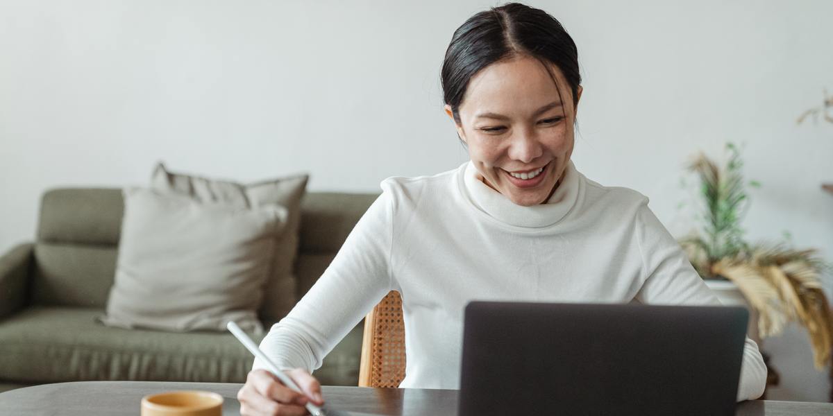 Young happy woman typing on laptop