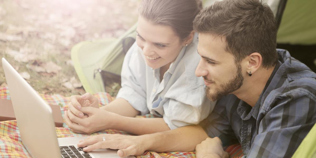 Happy couple binge-watching shows on laptop computer