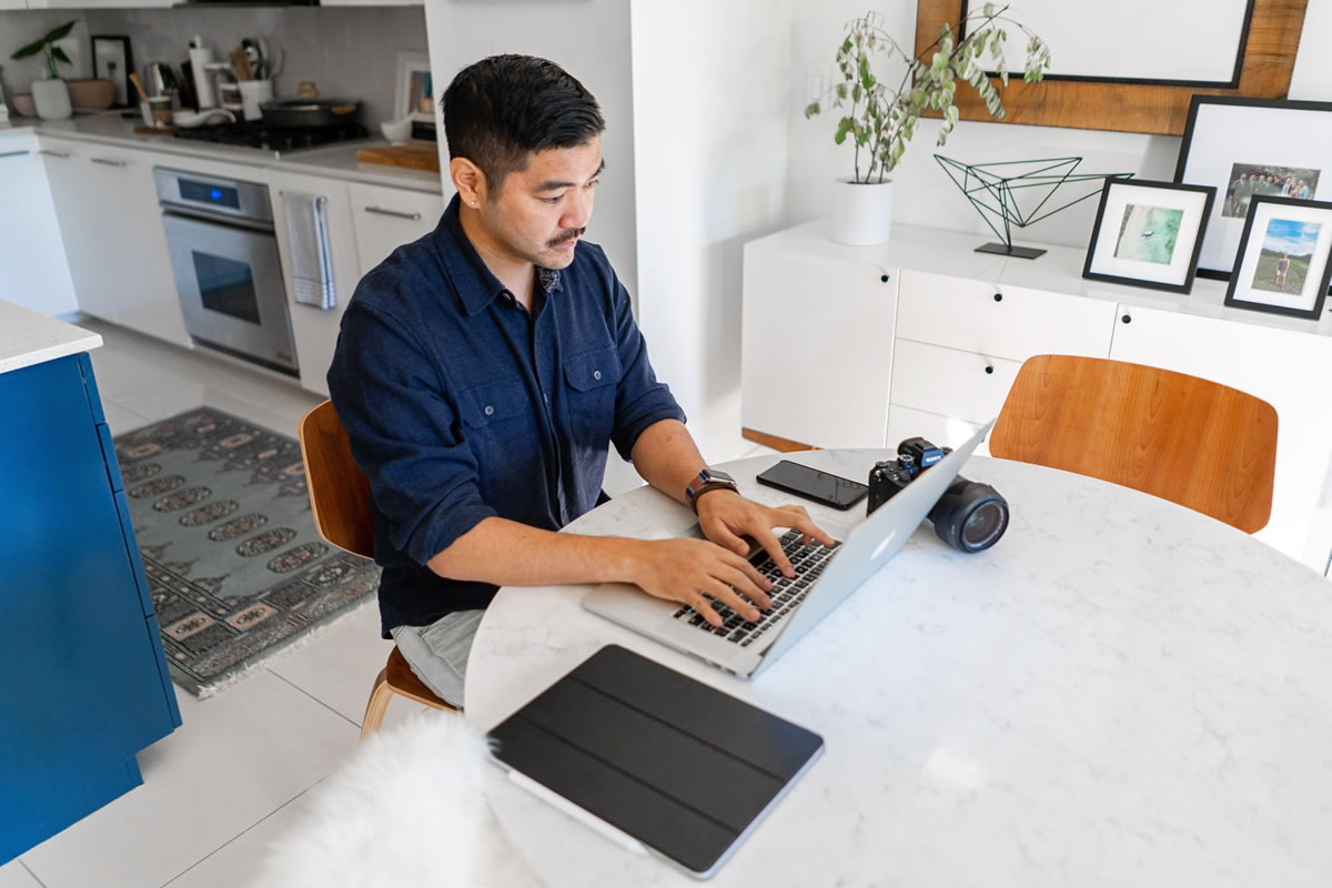 Professional entrepreneur writing on his laptop at home