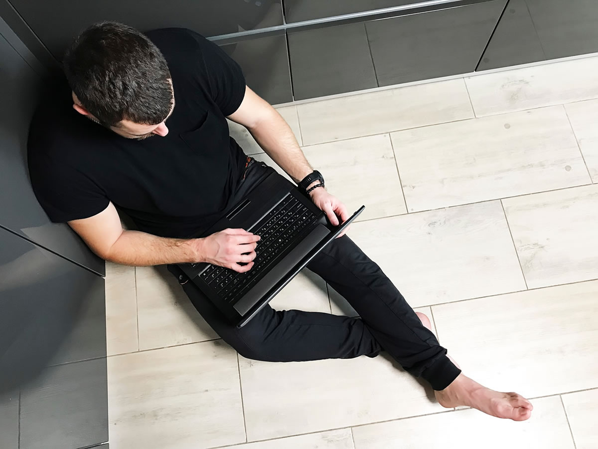 Barefoot man working on laptop