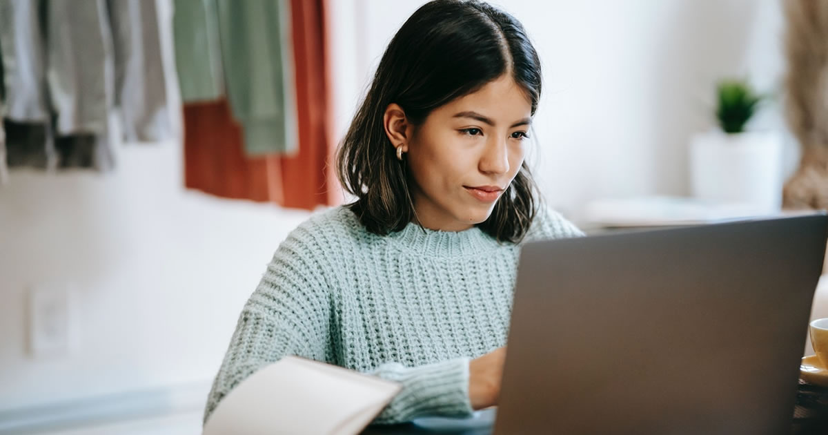 Woman writing on laptop from home