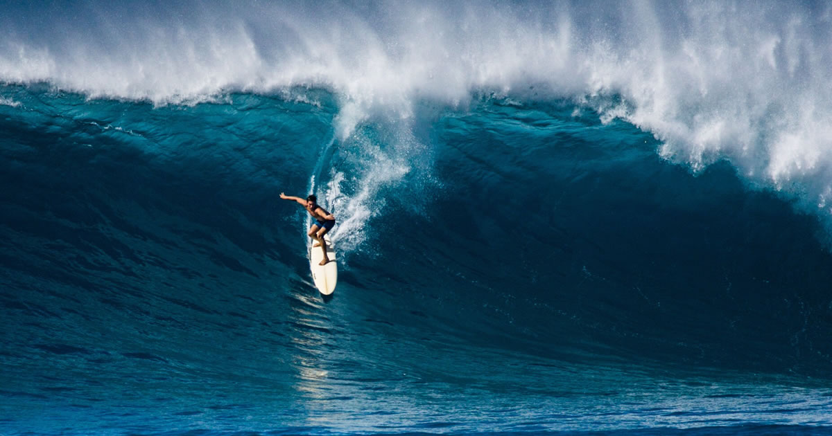 A surfer takes on Waimea Bay, Hawai'i