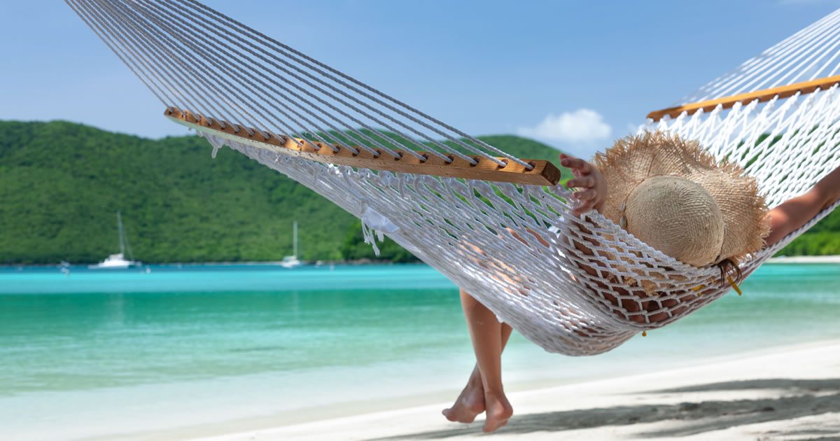 Woman relaxing in a hammock on a tropical beach