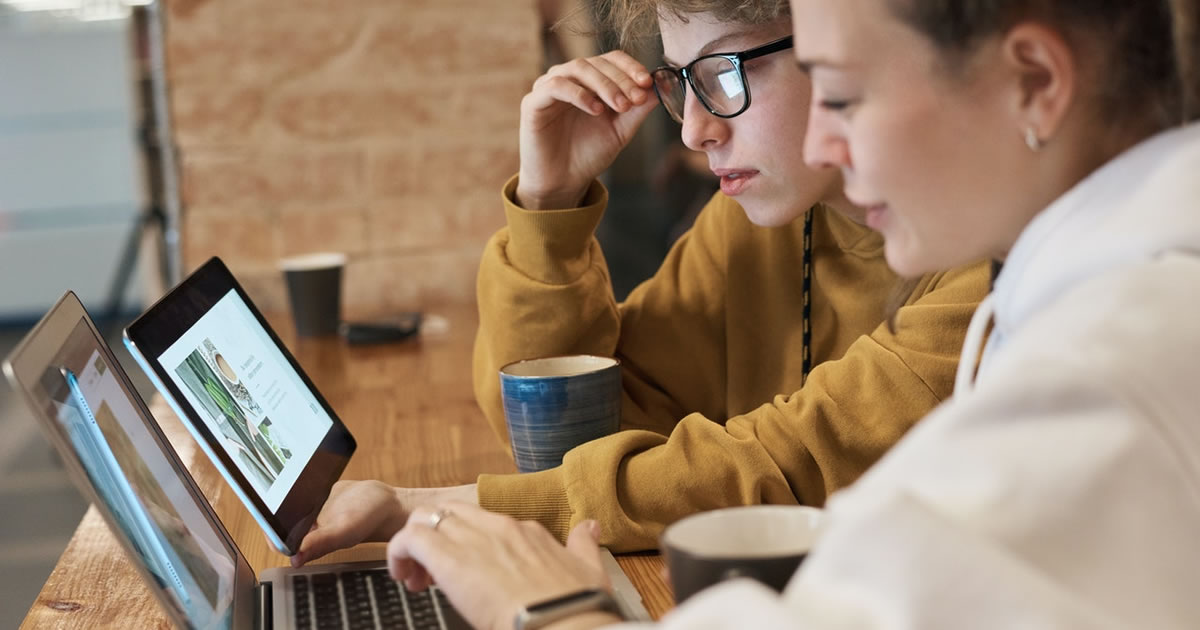 two businesswomen looking at laptop monitors