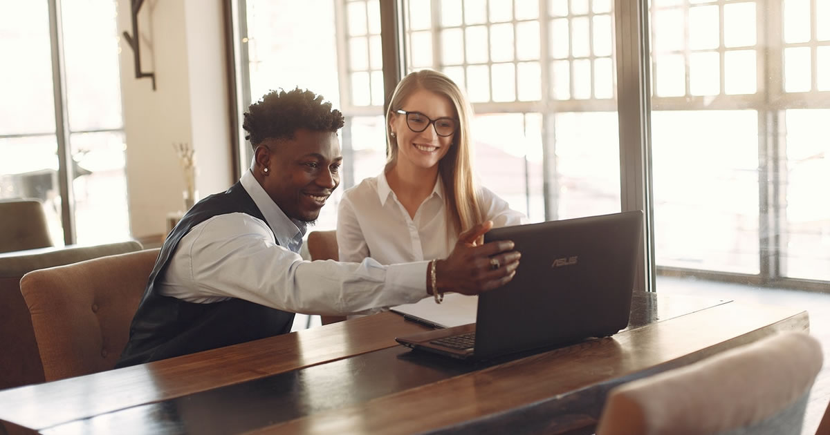 business colleagues looking at laptop at table