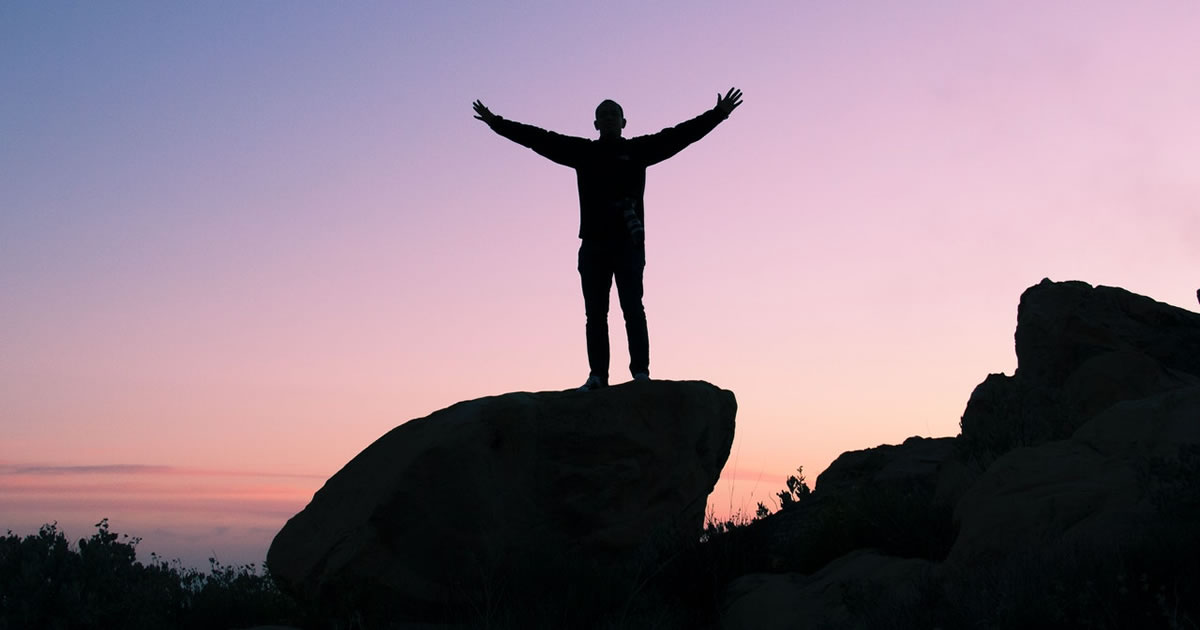 silhouette of man giving victory gesture outdoors