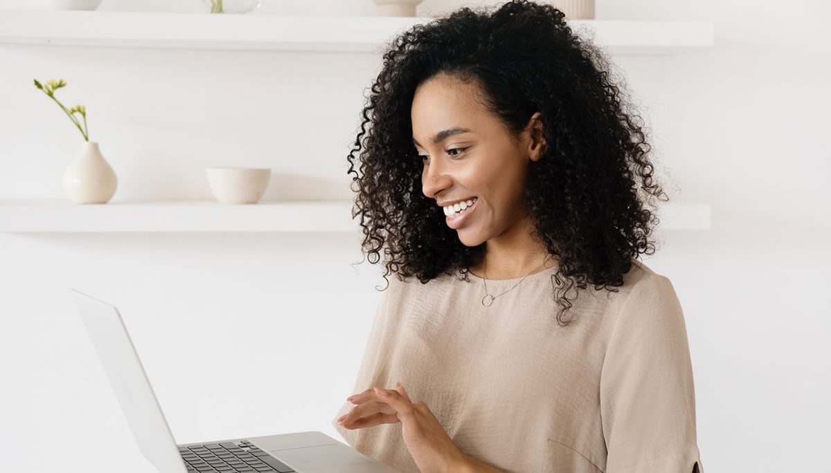 Smiling female freelance writer using laptop