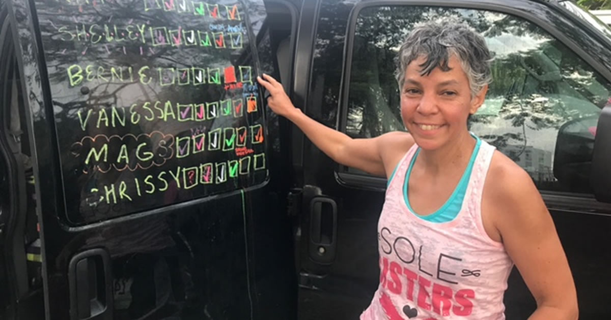 Writer Bernie Boyd standing next to list of participants after completing a relay race