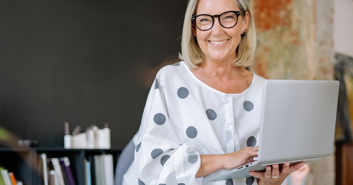 Elder happy woman holding laptop