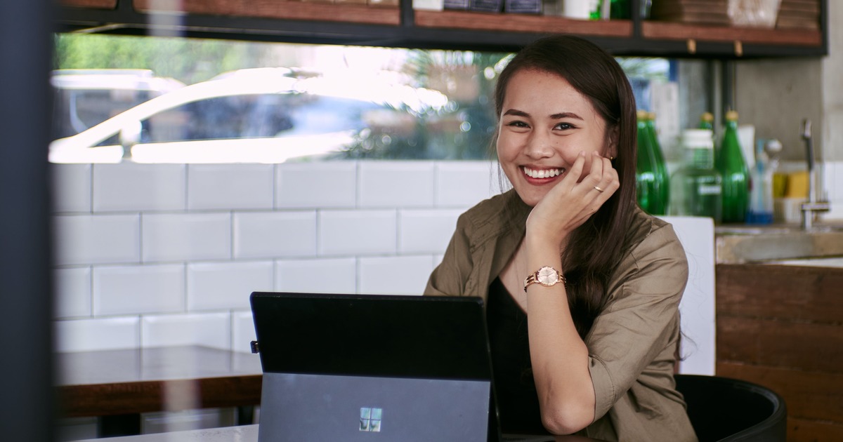 Writer smiling while typing on laptop