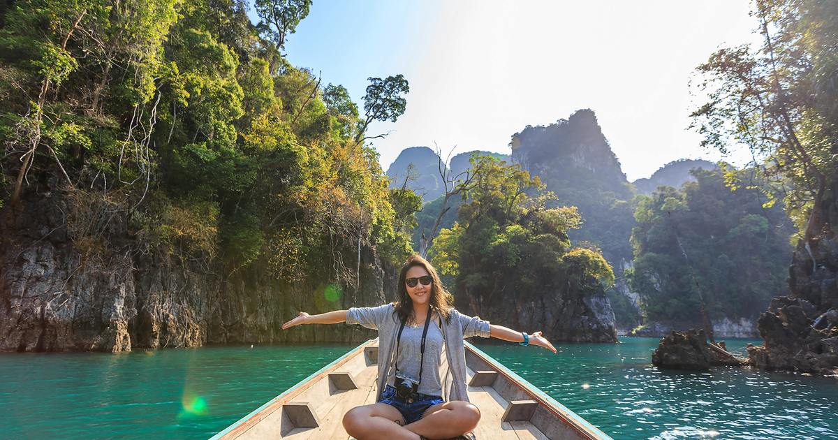 Happy writer with hands out to the side on boat