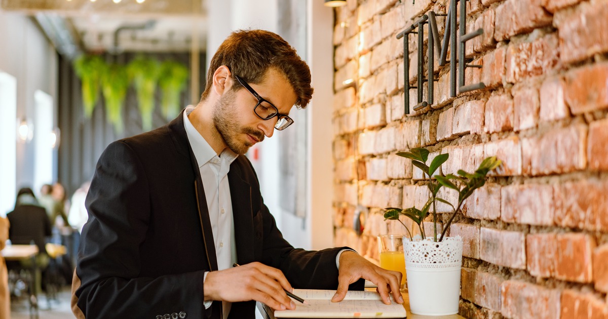 Writer standing writing in notebook