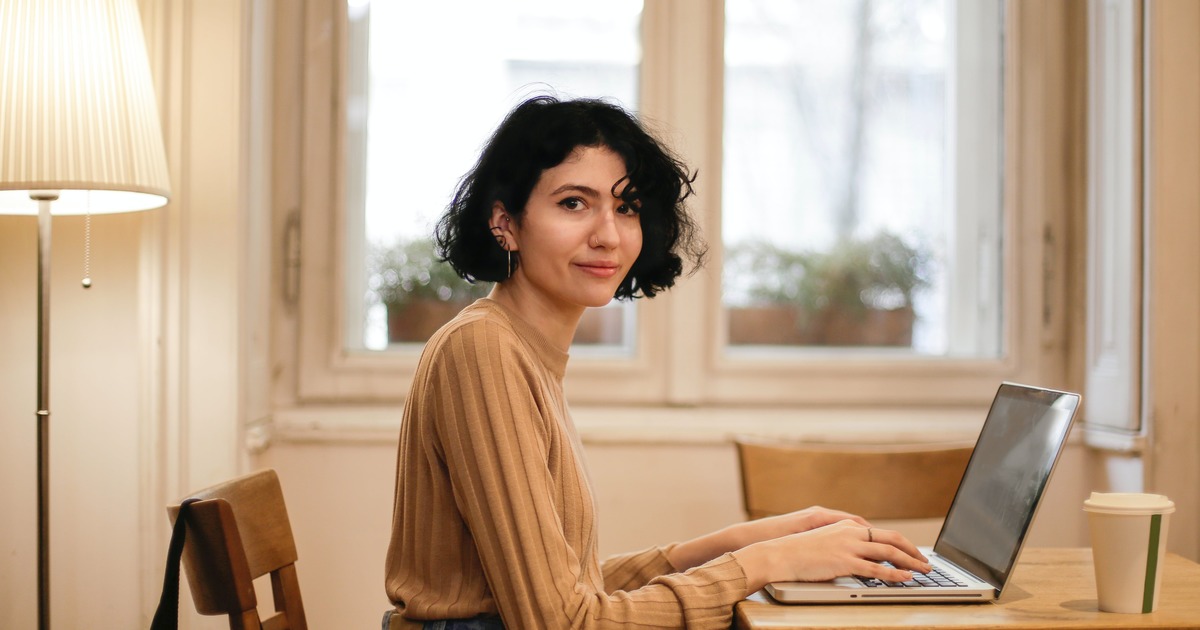 Writer smiling while typing on laptop