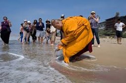 Photo of a monk collecting sand