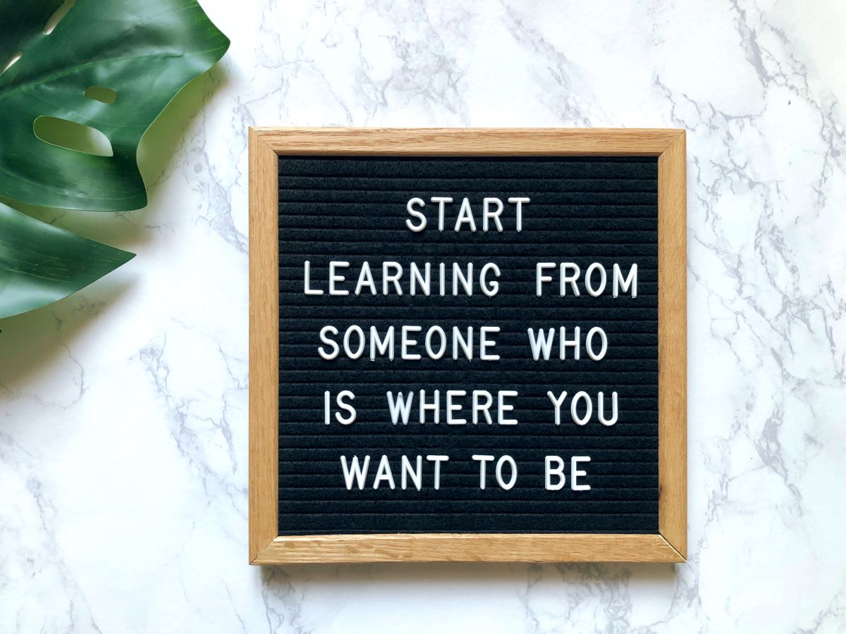 Board with letters that say Start Learning from Someone Who is Where You Want to Be