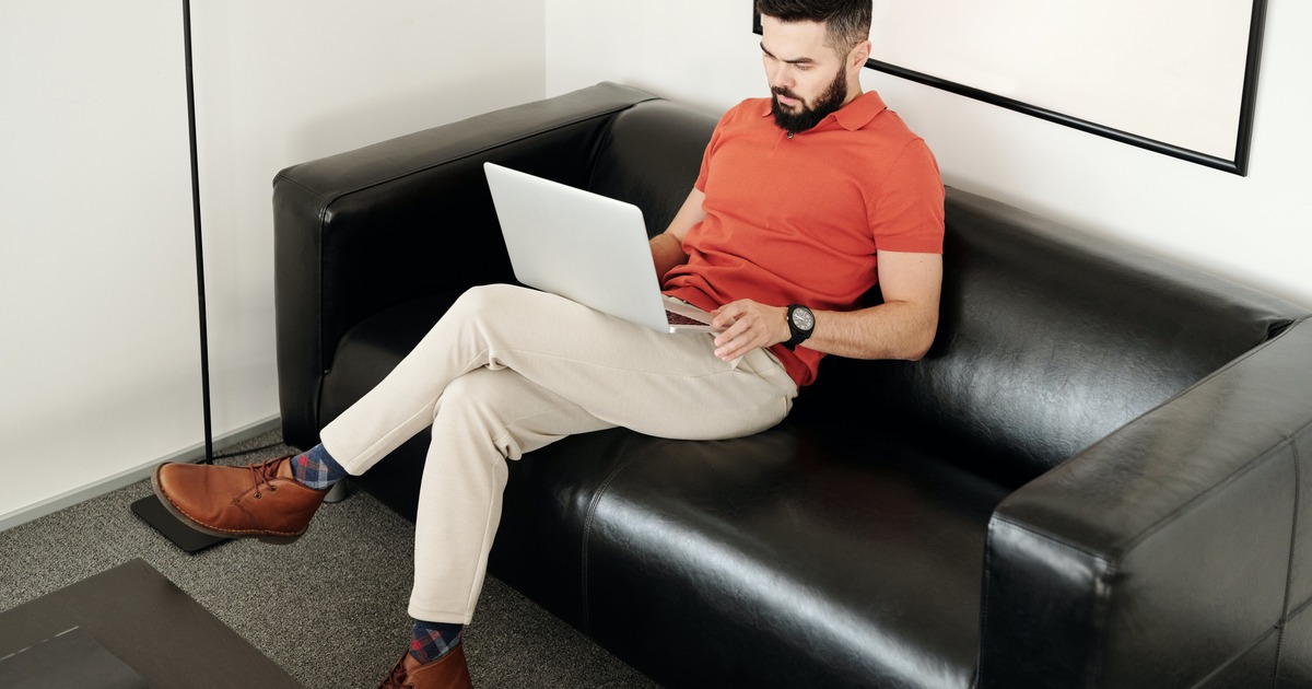 Writer sitting on a couch with laptop