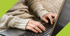 closeup of a woman's hands typing on laptop keyboard