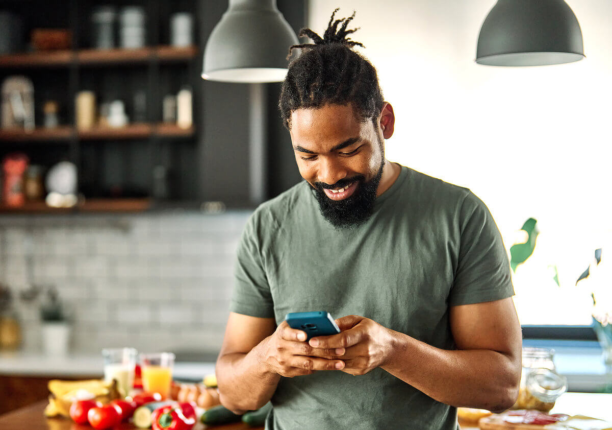 Male writer checking cell phone in kitchen